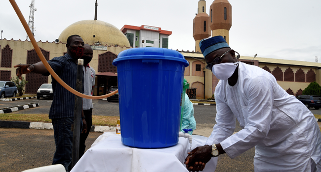 A man wash hands with sanitiser as he arrives at a Mosque following reopening of Mosques and lifting of restrictions on religious gatherings by the government as part of a set of measures taken to curtail the spread of COVID-19 Coronavirus at the Secretariat Community Central Mosque, Alausa in Lagos, on August 7, 2020. PIUS UTOMI EKPEI / AFP