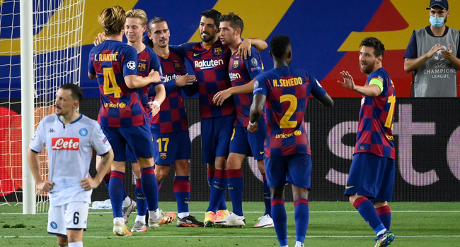 Barcelona's Uruguayan forward Luis Suarez (rear R) celebrates with teammates after scoring penalty kick during the UEFA Champions League round of 16 second leg football match between FC Barcelona and Napoli at the Camp Nou stadium in Barcelona on August 8, 2020. LLUIS GENE / AFP