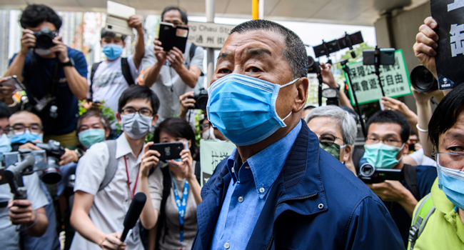 In this file photo taken on May 18, 2020, Hong Kong media tycoon and founder of the Apple Daily newspaper Jimmy Lai (C) arrives at the West Kowloon Magistrates Court for charges related to last year's protests in Hong Kong. Anthony WALLACE / AFP