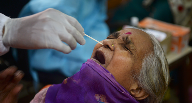 A health worker collects a swab sample of a resident to test for COVID-19 coronavirus, at a screening camp in Mumbai on August 17, 2020. Indranil MUKHERJEE / AFP