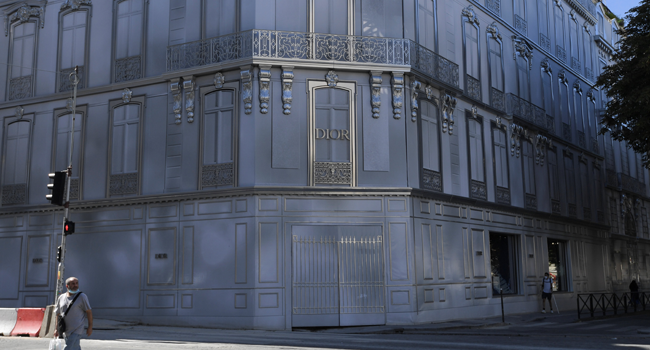 A man wearing a protective mask passes by a scaffolding by Dior on August 7, 2020 in Paris, amid the crisis linked with the covid-19 pandemic caused by the novel coronavirus. ALAIN JOCARD / AF