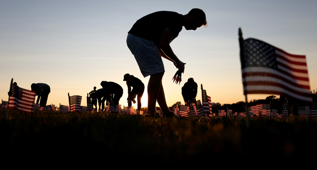 Volunteers with the COVID Memorial Project install 20,000 American flags on the National Mall as the United States crosses the 200,000 lives lost in the COVID-19 pandemic September 20, 2020 in Washington, DC. McNamee/Getty Images/AFP