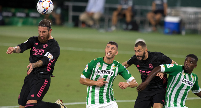 Real Madrid's Spanish defender Sergio Ramos (L) heads the ball next to Real Betis' Argentinian midfielder Guido Rodriguez, French forward Karim Benzema and Portuguese midfielder William Carvalho during the Spanish league football match Real Betis against Real Madrid CF at the Benito Villamarin stadium in Seville on September 26, 2020. JORGE GUERRERO / AFP