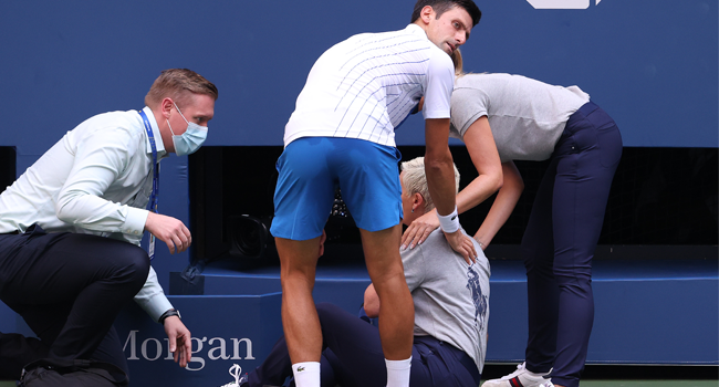 Novak Djokovic of Serbia tends to a line judge who was hit with the ball during his Men's Singles fourth round match against Pablo Carreno Busta of Spain on Day Seven of the 2020 US Open at the USTA Billie Jean King National Tennis Center on September 6, 2020 in the Queens borough of New York City. Al Bello/Getty Images/AFP