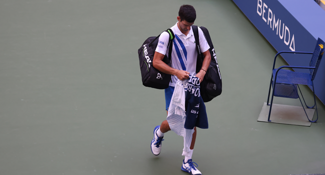 Novak Djokovic of Serbia walks off the court after being defaulted due to inadvertently striking a lineswoman with a ball hit in frustration during his Men's Singles fourth round match against Pablo Carreno Busta of Spain on Day Seven of the 2020 US Open at the USTA Billie Jean King National Tennis Center on September 6, 2020 in the Queens borough of New York City. Al Bello/Getty Images/AFP
