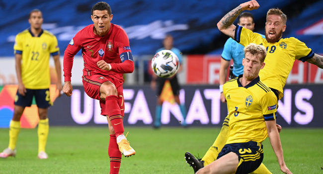 Portugal's forward Cristiano Ronaldo (L) shoots past Sweden's defender Filip Helander (C) and Sweden's defender Pontus Jansson during the UEFA Nations League football match between Sweden and Portugal on September 8, 2020 in Solna, Sweden. Jonathan NACKSTRAND / AFP