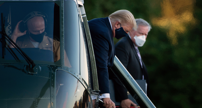 White House Chief of Staff Mark Meadows (R) watches as US President Donald Trump walks off Marine One while arriving at Walter Reed Medical Center in Bethesda, Maryland on October 2, 2020, after testing positive for covid-19. Brendan Smialowski / AFP