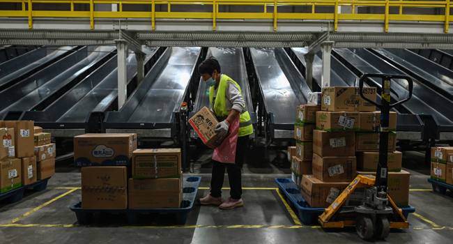 In this picture taken on November 6, 2020, an employee works in the warehouse of Cainiao Smart Logistics Network, the logistics affiliate of e-commerce giant Alibaba, in Wuxi, China's eastern Jiangsu province, ahead of Singles' Day, also known as the Double 11 shopping festival - the world's biggest shopping event - which falls on November 11. Hector RETAMAL / AFP