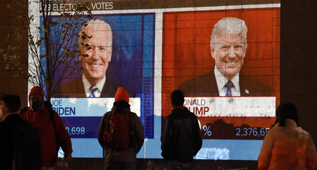 People watch a big screen displaying the live election results in Florida at Black Lives Matter plaza across from the White House on election day in Washington, DC on November 3, 2020. Olivier DOULIERY / AFP