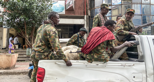 Members of the Amhara militia, that combat alongside federal and regional forces against northern region of Tigray, ride on the back of a pick up truck in the city of Gondar, on 08 November 2020. EDUARDO SOTERAS / AFP