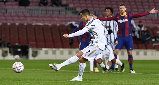 Juventus' Portuguese forward Cristiano Ronaldo scores his team's third goal during the UEFA Champions League group G football match between Barcelona and Juventus at the Camp Nou stadium in Barcelona on December 8, 2020. Josep LAGO / AFP