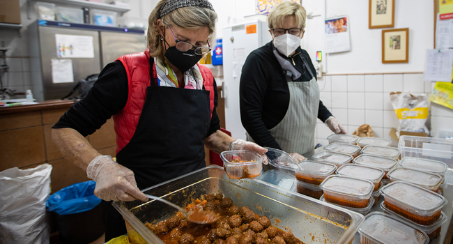 Volunteers prepare food packages to be distributed to people in need at the Zaqueo Association in Palma de Mallorca on December 2, 2020. JAIME REINA / AFP