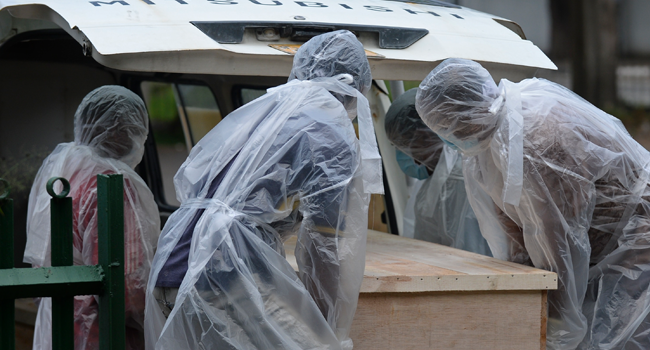 Municipal workers carry the coffin of an unclaimed body of a Covid-19 coronavirus victim to a crematorium in Colombo on December 10, 2020. Lakruwan WANNIARACHCHI / AFP