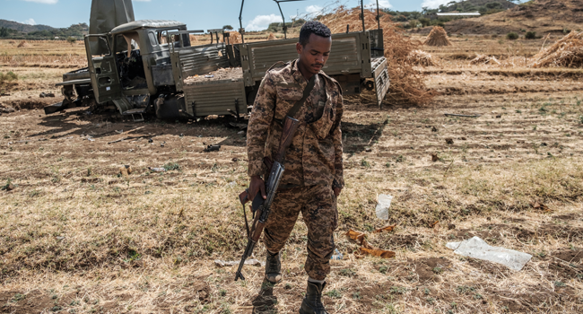 A member of the Ethiopian Defense Forces walks away from a damaged military truck abandoned on a road near the village of Ayasu Gebriel, East of the Ethiopian city of Alamata, on December 10, 2020. EDUARDO SOTERAS / AFP