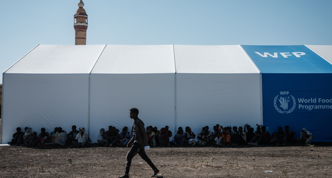 Ethiopian refugees who fled the Tigray conflict rest in the shadow of a warehouse erected by the World Food Programme (WFP) at Village Eight transit centre near the Ethiopian border in Gedaref, eastern Sudan, on December 2, 2020. Yasuyoshi CHIBA / AFP