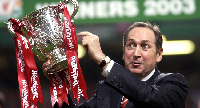 In this file photo taken on March 2, 2003 Liverpool's French manager Gerard Houllier holds the cup aloft celebrating victory over Manchester United in the Worthington cup final at the Millenium stadium in Cardiff. Ex-Liverpool manager Gerard Houllier has died at the age of 73, it was announced on December 14, 2020. Odd ANDERSEN / AFP
