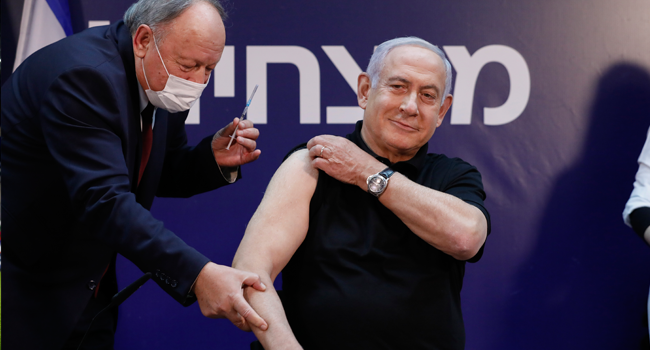 Israeli Prime Minister Benjamin Netanyahu receives a coronavirus vaccine at the Sheba Medical Center, the country's largest hospital, in Ramat Gan near the coastal city of Tel Aviv, on December 19, 2020. AMIR COHEN / POOL / AFP
