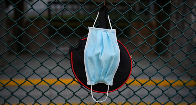 In this photo taken on December 2, 2020 a face mask hangs with a table tennis bat cover at a park in Beijing. GREG BAKER / AFP