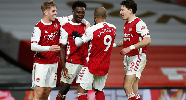 Arsenal's English striker Bukayo Saka (2L) celebrates scoring their thrid goal during the English Premier League football match between Arsenal and Chelsea at the Emirates Stadium in London on December 26, 2020. ANDREW BOYERS / POOL / AFP