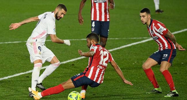 Real Madrid's French forward Karim Benzema (L) vies with Atletico Madrid's Brazilian defender Renan Lodi during the Spanish league football match between Real Madrid CF and Club Atletico de Madrid at the Alfredo di Stefano stadium in Madrid on December 12, 2020. OSCAR DEL POZO / AFP