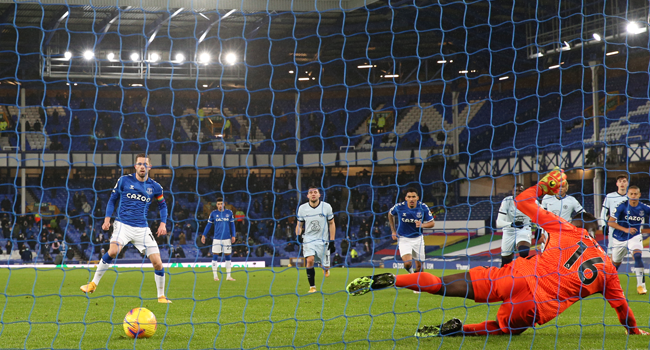 Everton's Icelandic midfielder Gylfi Sigurdsson (L) scores the opening goal from the penalty spot as Chelsea's French goalkeeper Edouard Mendy (R) dives the wrong way during the English Premier League football match between Everton and Chelsea at Goodison Park in Liverpool, north west England on December 12, 2020. Clive Brunskill / POOL / AFP