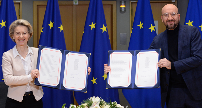 European Commission President Ursula von der Leyen (L) and European Council President Charles Michel (R) pose in Brussels, on December 30, 2020 as they show the signed Brexit trade agreement due to come into force on January 1, 2021.  JOHANNA GERON / POOL / AFP