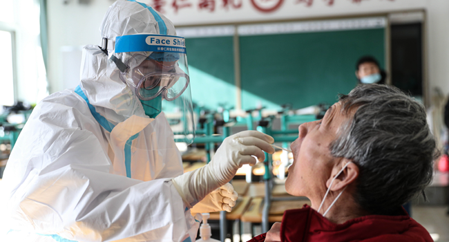 A medical worker takes a swab sample from a resident to test for the COVID-19 coronavirus in Shenyang, in China's northeast Liaoning province on December 31, 2020. STR / AFP