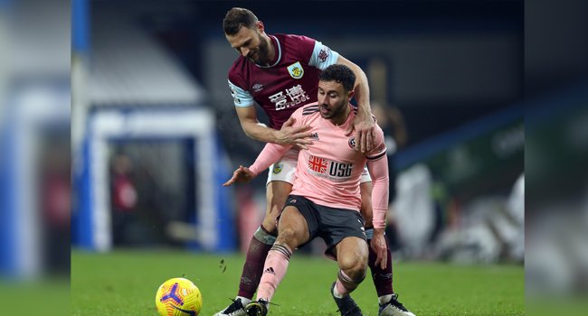 Burnley's Dutch defender Erik Pieters challenges Sheffield United's English defender George Baldock during the English Premier League football match between Burnley and Sheffield United at Turf Moor in Burnley, north west England on December 29, 2020. Barrington Coombs / POOL / AFP