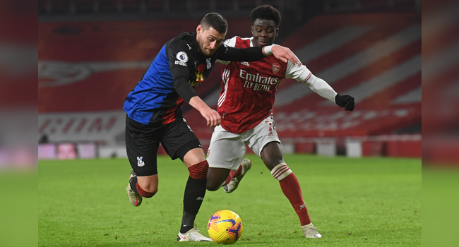 Crystal Palace's English defender Joel Ward (L) vies with Arsenal's English striker Bukayo Saka (R) during the English Premier League football match between Arsenal and Crystal Palace at the Emirates Stadium in London on January 14, 2021. NEIL HALL / POOL / AFP