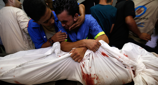  In this file photo taken on August 21, 2014 a Palestinian man mourns over the body of his relative Rami Abu Nahel, killed in an Israeli military strike, at Gaza city's Al-Shifa hospital. MOHAMMED ABED / AFP