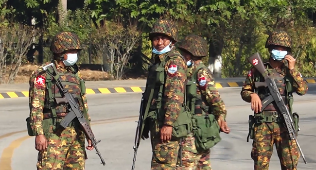 Soldiers stand guard on a street in Naypyidaw on February 1, 2021, after the military detained the country's de facto leader Aung San Suu Kyi and the country's president in a coup. STR / AFP