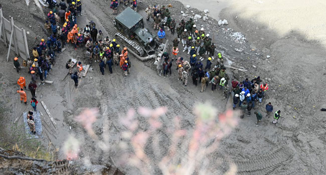 Rescue teams gather near the entrance of a tunnel blocked with mud and debris, where workers are trapped, in Tapovan of Chamoli district on February 9, 2021 following a flash flood thought to have been caused when a glacier burst on February 7. Sajjad HUSSAIN / AFP