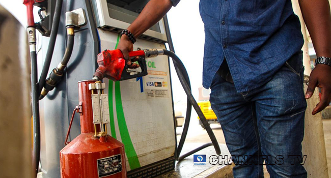 A file photo of a man filling up a measuring canister. Photo: Sodiq Adelakun/Channels Television