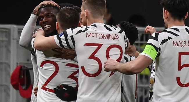 Manchester United's France's midfielder Paul Pogba (L) celebrates after opening the scoring during the UEFA Europa League round of 16 second leg football match between AC Milan and Manchester United at San Siro stadium in Milan on March 18, 2021. Marco BERTORELLO / AFP