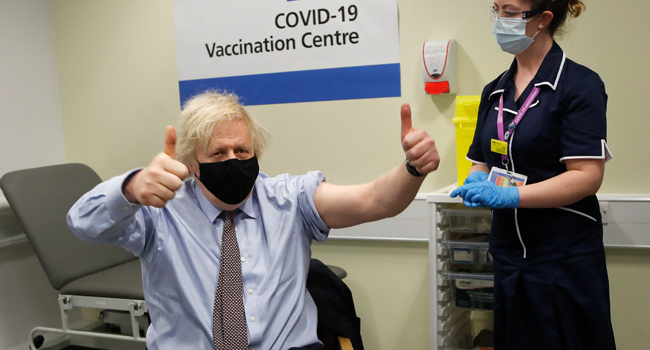 Britain's Prime Minister Boris Johnson makes a 'thumbs-up' gesture after he received a dose of a AstraZeneca/Oxford Covid-19 vaccine, administered by nurse and Clinical Pod Lead, Lily Harrington, at the vaccination centre in St Thomas' Hospital in London on March 19, 2021. Frank Augstein / POOL / AFP