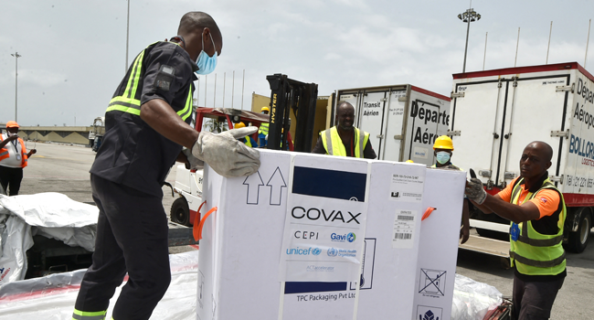 Workers unload a shipment of AstraZeneca Covid-19 vaccine bearing Covax stickers from a plane at Felix Houphouet Boigny airport of Abidjan on February 26, 2021. SIA KAMBOU / AFP