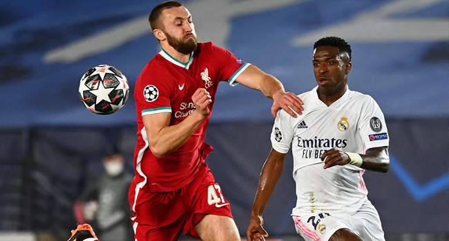 Liverpool's English defender Nathaniel Phillips challenges Real Madrid's Brazilian forward Vinicius Junior (R) during the UEFA Champions League first leg quarter-final football match between Real Madrid and Liverpool at the Alfredo di Stefano stadium in Valdebebas in the outskirts of Madrid on April 6, 2021. GABRIEL BOUYS / AFP