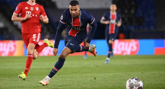 Paris Saint-Germain's French forward Kylian Mbappe (R) drives the ball during the UEFA Champions League quarter-final second leg football match between Paris Saint-Germain (PSG) and FC Bayern Munich at the Parc des Princes stadium in Paris, on April 13, 2021. FRANCK FIFE / AFP