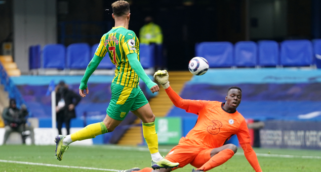 West Bromwich Albion's English striker Callum Robinson (L)scores his team's fifth goal past Chelsea's French-born Senegalese goalkeeper Edouard Mendy during the English Premier League football match between Chelsea and West Bromwich Albion at Stamford Bridge in London on April 3, 2021. John Walton / POOL / AFP