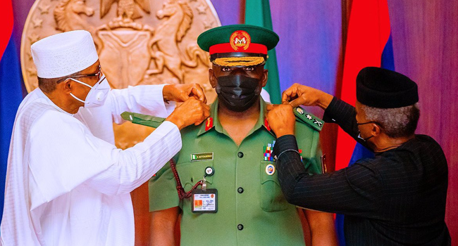 Lieutenant-General Ibrahim Attahiru (c) being decorated by President Muhammadu Buhari (L) and Vice President Yemi Osinbajo.