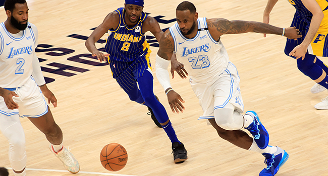 LeBron James #23 of the Los Angeles Lakers drives to the basket while guarded by Justin Holiday #8 of the Indiana Pacers during the fourth quarter at Bankers Life Fieldhouse on May 15, 2021 in Indianapolis, Indiana. Justin Casterline/Getty Images/AFP