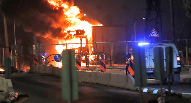 A truck burns at the entrance of the mixed Jewish-Arab city of Lod, where a state of emergency has been declared following civil unrest, on May 12, 2021.  Ahmad GHARABLI / AFP