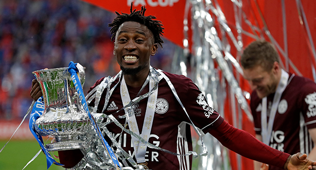 Leicester City's Nigerian midfielder Wilfred Ndidi holds the winner's trophy as the Leicester players celebrate victory after the English FA Cup final football match between Chelsea and Leicester City at Wembley Stadium in north west London on May 15, 2021. Kirsty Wigglesworth / POOL / AFP