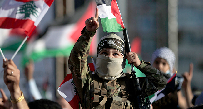 A child wearing a military outfit and brandishing a toy gun takes part along with Lebanese and Palestinians in a rally to celebrate the recent cease-fire between Hamas and Israel, in the capital Beirut's central Martyr's square, on May 22, 2021, after which the two rival sides claimed victory. ANWAR AMRO / AFP