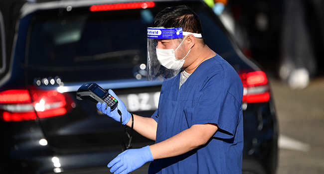 A health worker registers people for Covid-19 coronavirus tests at a drive-through testing centre at Bondi beach in Sydney on June 25, 2021, as authorities locked down several central areas of Australia's largest city to contain an outbreak of the highly contagious Delta variant. SAEED KHAN / AFP