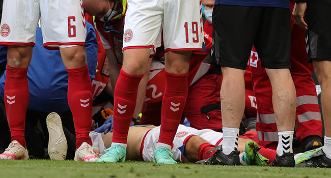 Denmark's players gather as paramedics attend to midfielder Christian Eriksen (not seen) during the UEFA EURO 2020 Group B football match between Denmark and Finland at the Parken Stadium in Copenhagen on June 12, 2021. Friedemann Vogel / POOL / AFP