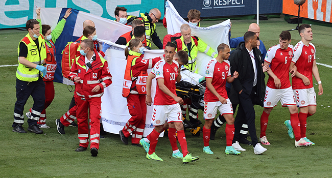 Denmark's players gather as paramedics attend to midfielder Christian Eriksen (not seen) during the UEFA EURO 2020 Group B football match between Denmark and Finland at the Parken Stadium in Copenhagen on June 12, 2021. WOLFGANG RATTAY / AFP / POOL