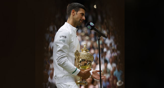 Serbia's Novak Djokovic speaks as he holds the winner's trophy after beating Italy's Matteo Berrettini during their men's singles final match on the thirteenth day of the 2021 Wimbledon Championships at The All England Tennis Club in Wimbledon, southwest London, on July 11, 2021. Adrian DENNIS / AFP