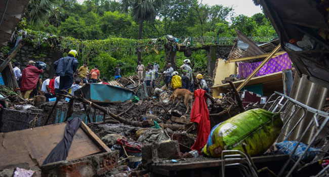 National Disaster Response Force (NDRF) and other rescue team personnel inspect the site of the landslide in a slum area where 18 people were killed after several homes were crushed by a collapsed wall and a landslide triggered by heavy monsoon rains in Mumbai on July 18, 2021. Sujit Jaiswal / AFP