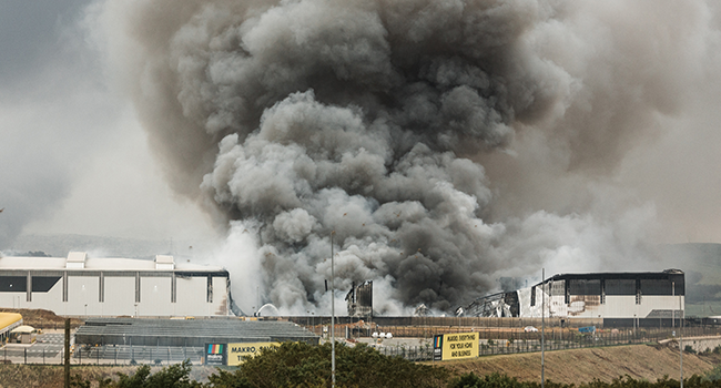 Smoke rises from a Makro building set on fire overnight in Umhlanga, north of Durban, on July 13, 2021 as several shops, businesses and infrastructure are damaged in the city, following four nights of continued violence and looting sparked by the jailing of ex-president Jacob Zuma. RAJESH JANTILAL / AFP